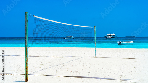 Volleyball net on a deserted sandy beach on the tropical sea.