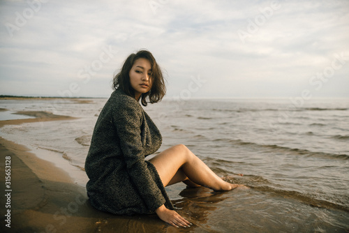 Woman portrait in coat on sea beach 
