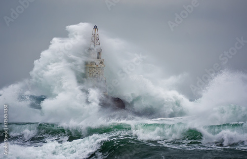 Fototapeta Naklejka Na Ścianę i Meble -  Lighthouse In Stormy Landscape. Storm waves over the Lighthouse -Ahtopol, Black Sea, Bulgaria.