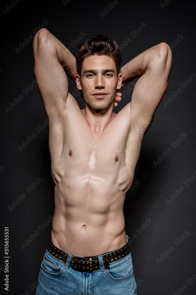 sexy young man with muscular torso posing on black background sexy young man with muscular torso posing on black background
