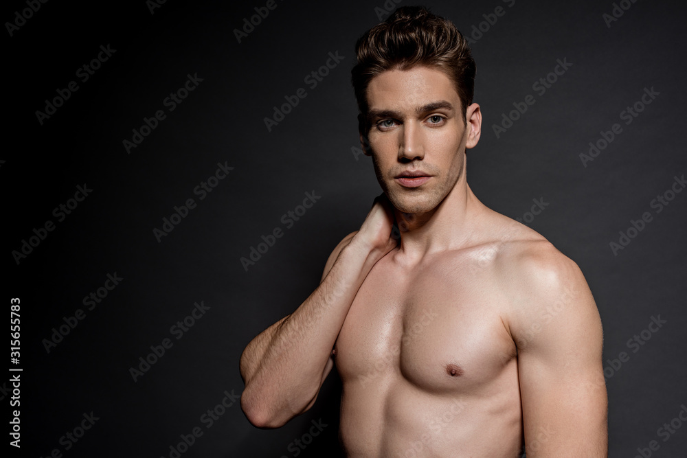 Fototapeta premium sexy young naked man with muscular torso posing on black background