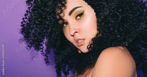 Εκτύπωση καμβά Portrait of a rastafarian woman with afro hairstyle and color make-up on a violet background