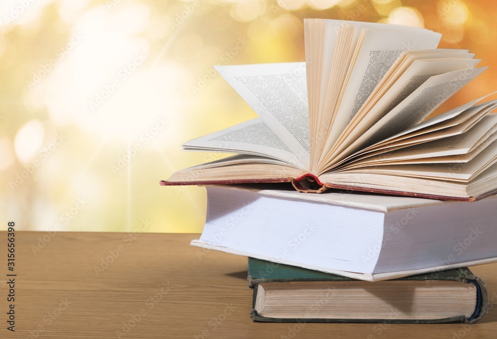 Old open book on stack books with a background. Old open book on stack books with a background.