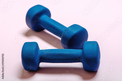 Pair of dumbbells on pink background.