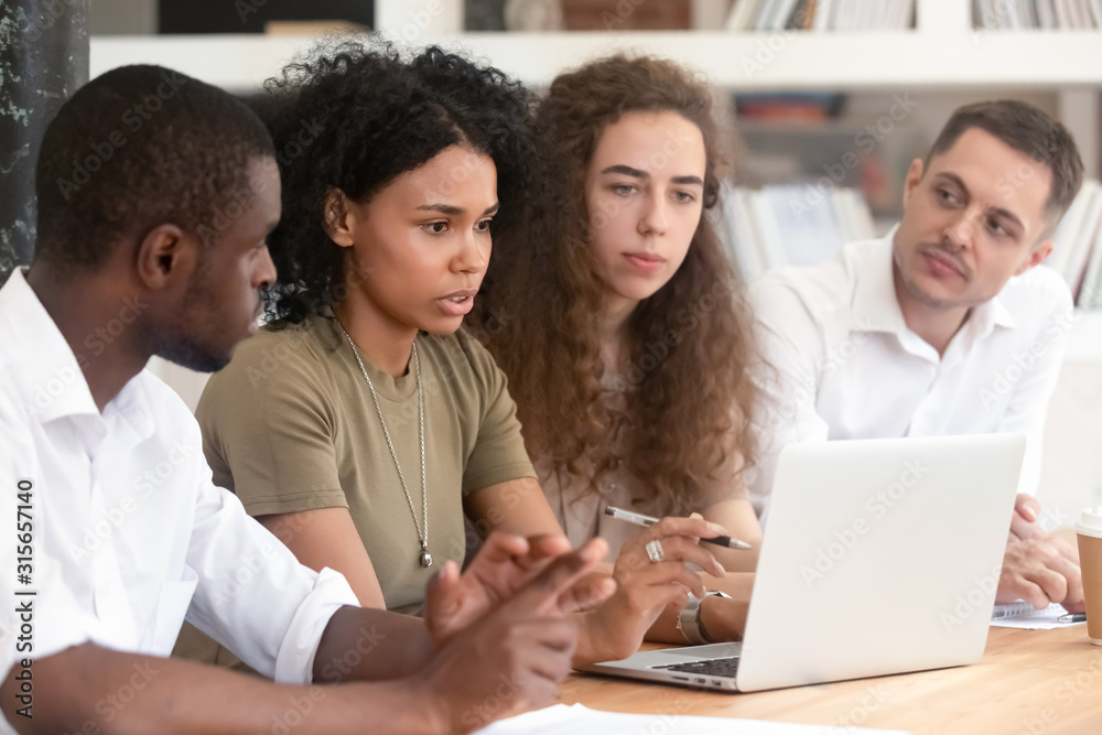 Focused multiracial group discuss business ideas together Focused multiracial group discuss business ideas together