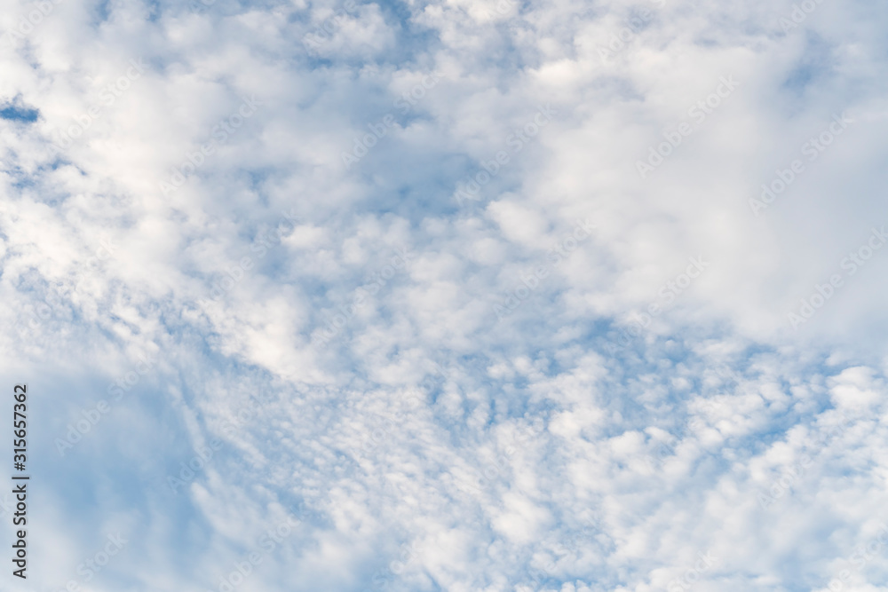 Beautiful cirrus clouds completely cover the blue sky. Positive abstract background
