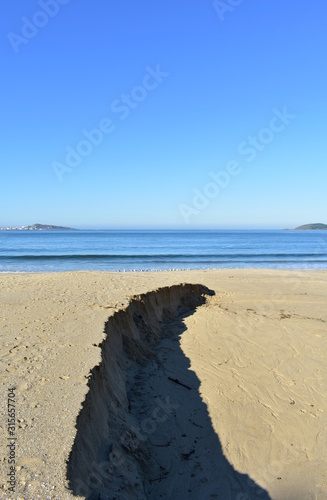 Beach with sand dunes, seagulls and blue sea on a sunny day. Muxia, Coruña, Galicia, Spain.
