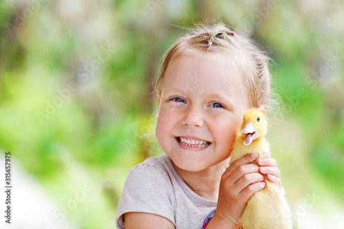 Portrait of a little girl holding a duck. Copy space