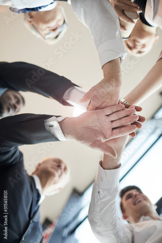 Low angle view of business team holding hands and support each other before meeting at office