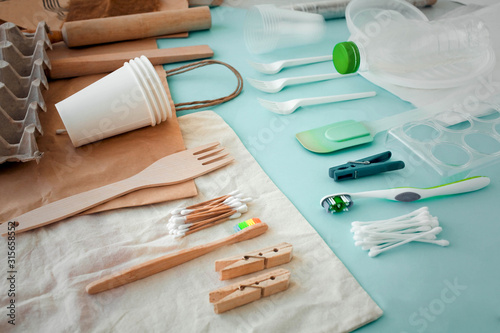 Disposable plastic dishes, bags, toothbrush, clothespins and cotton buds made of wood and plastic.Eco, plastic free and save earth concept. photo