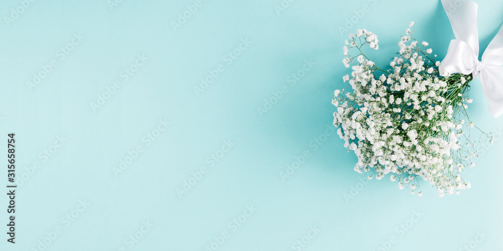 Obraz premium Flowers composition romantic. Bouquet white flowers gypsophila on pastel blue background. Valentines Day, Easter, Birthday, Happy Women's Day, Mother's day. Flat lay, top view, copy space