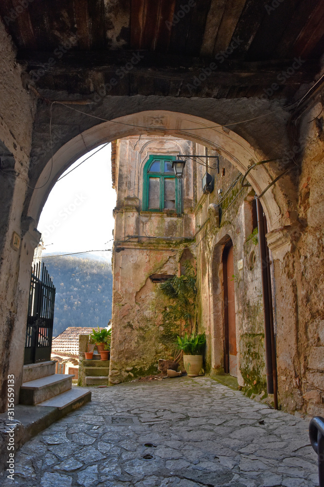 Fototapeta premium Prata Sannita, Italy, 01/13/2020. A narrow street between the old houses of a medieval village