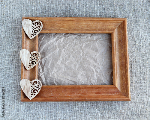 Wooden heart on crumpled paper in a frame
