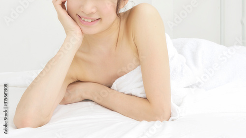 ベッドで横になる若い女性