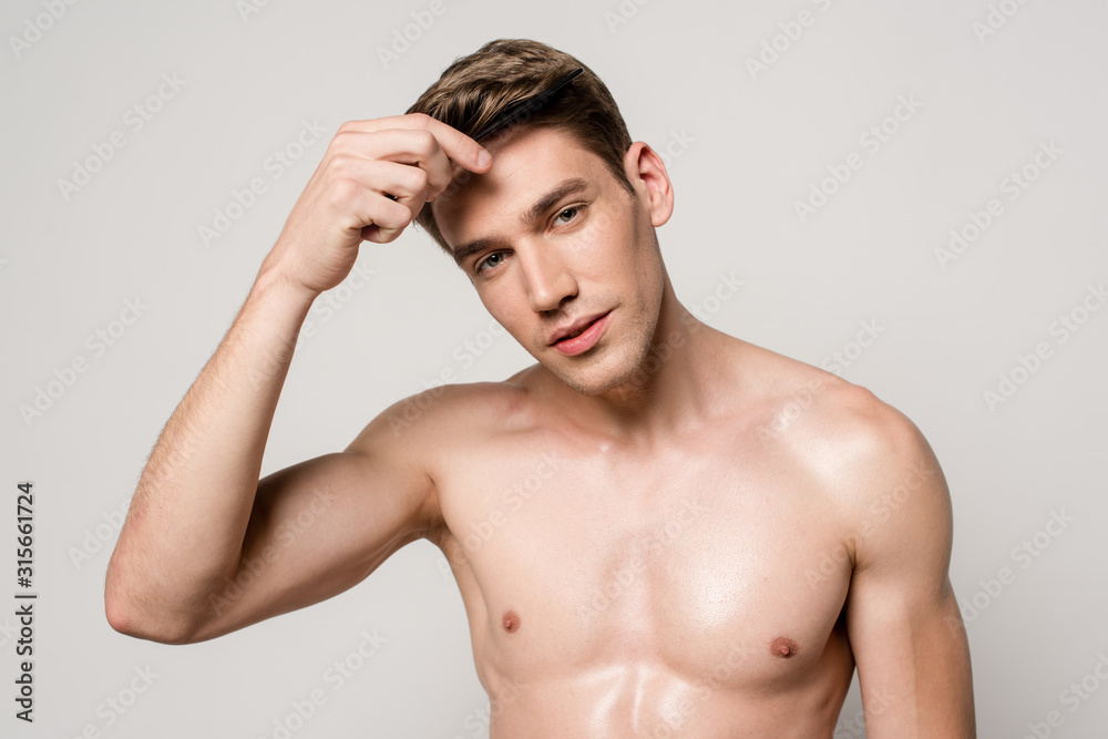 sexy man with muscular torso holding comb isolated on grey sexy man with muscular torso holding comb isolated on grey