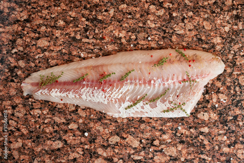 Fresh raw pike perch fish fillet on marble dark brown table. Top view photo