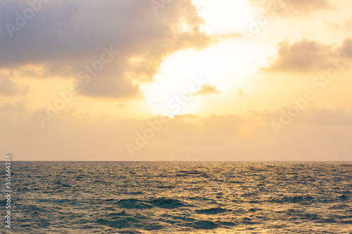 dramatic cloudy sunset sky background above horizon scenic view Mediterranean sea wavy surface wallpaper pattern picture with empty copy space for your text here