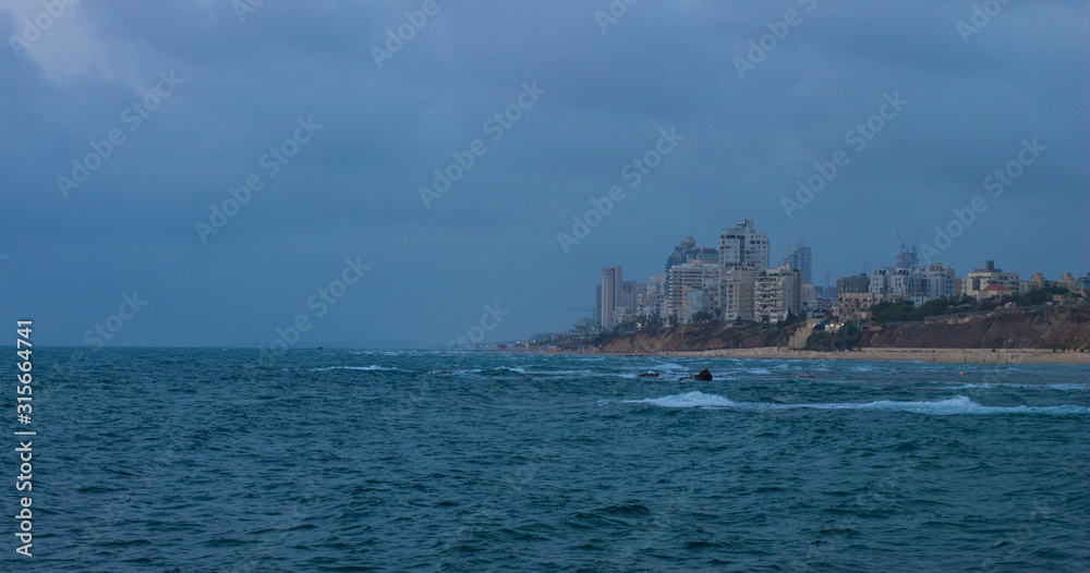 Tel Aviv outskirts city Bat Yam landmark landscape view Mediterranean sea waterfront soft focus buildings in stormy moody cloudy weather time, copy space