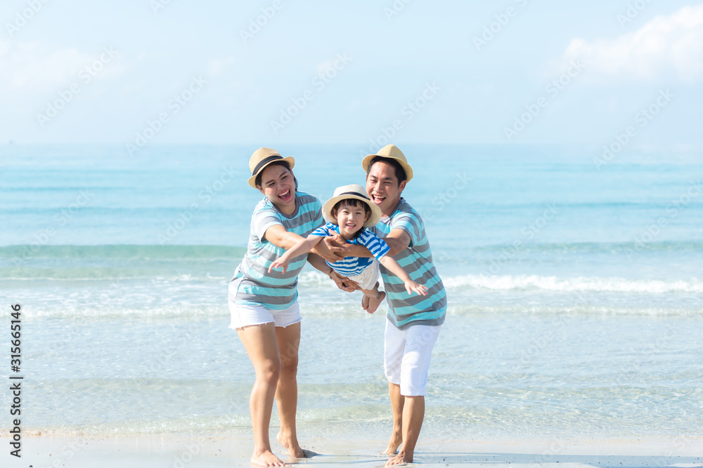 Asian happy family have fun fly on the beach for leisure and destination.  Family people tourism travel enjoy in summer and holiday.  Travel and Family Concept