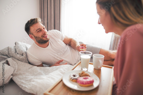 Young couple having a breakfast in the bed