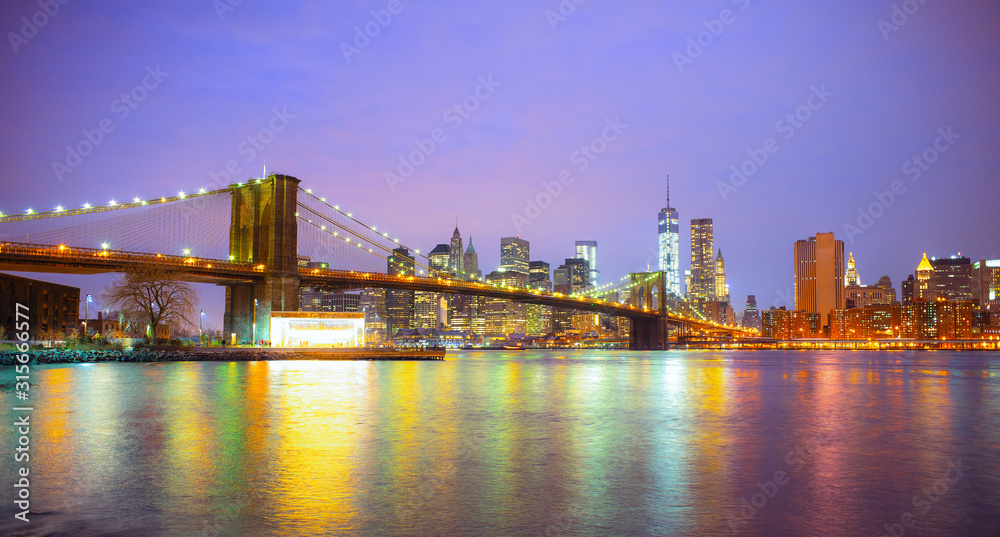 New York City skyline, the Brooklyn Bridge, reflection on the Hudson river. United States of America