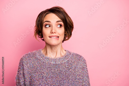 Close-up portrait of her she nice attractive lovely lovable pretty cute charming girlish funny unsure brown-haired girl biting lip looking aside isolated over pink pastel color background photo
