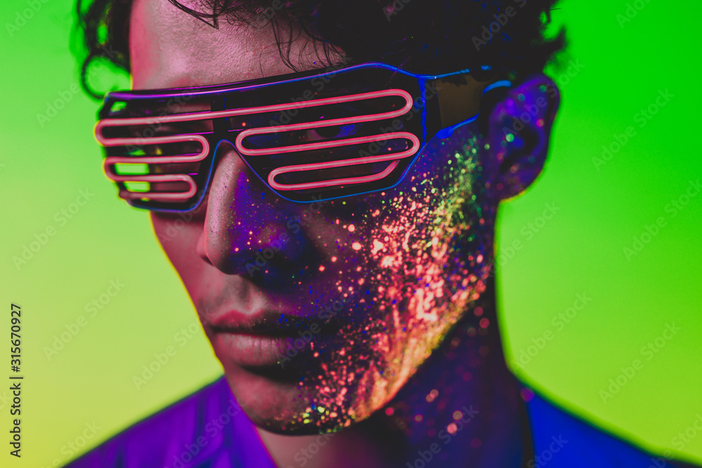Handsome boy dancing at the rave party with fluorescent paintings on ...