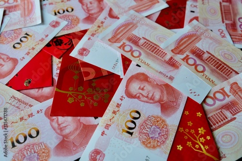 Yuan banknote of China and bright red envelope have auspicious and word patterns for money to be given to lover, children and staff in the Chinese New Year festival to show kindness, good hope, wishes