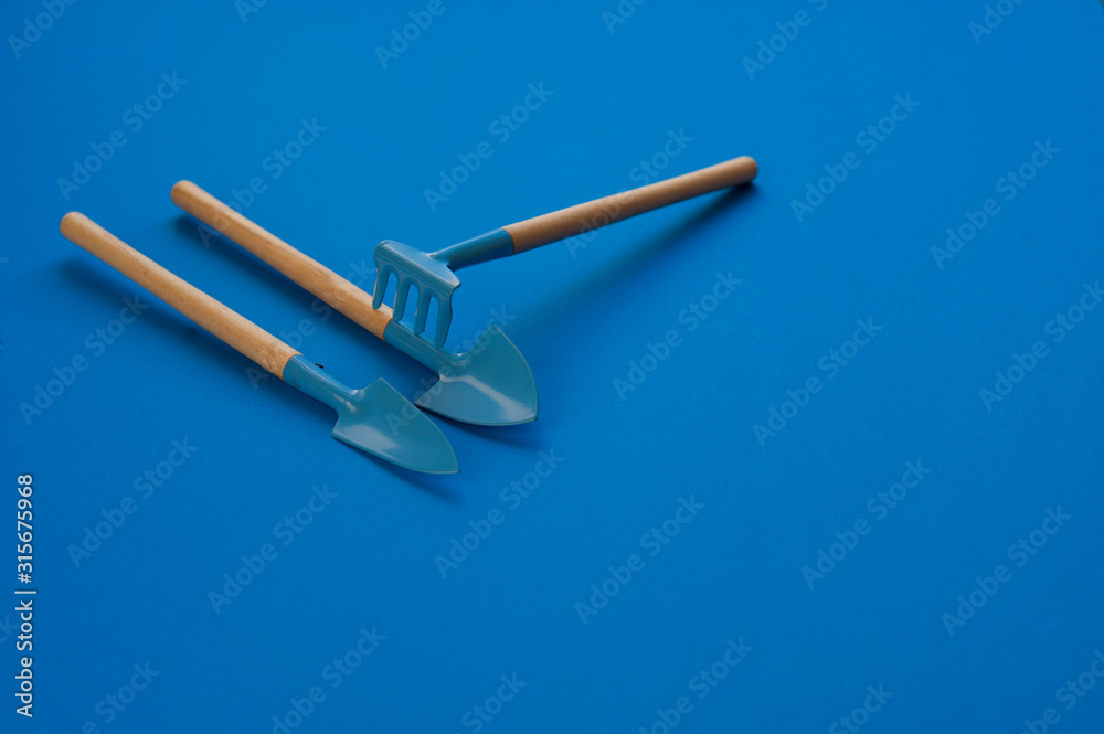 resource of gardening tools rake on digging shovel on blue classic background resource of gardening tools rake on digging shovel on blue classic background