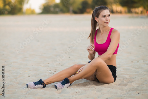 Beautiful girl with a smart watch goes in for sports on the beach