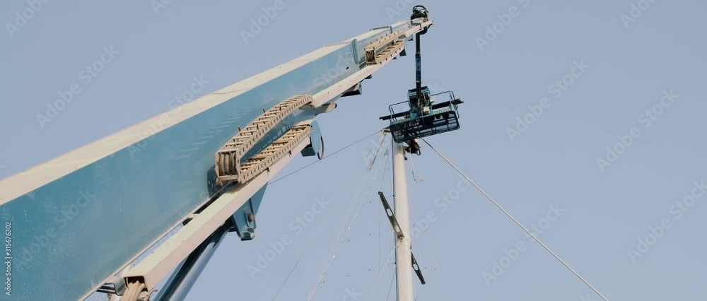 High crane lifting workers on a construction site