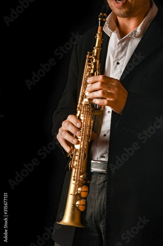 soprano saxophone in the hands of a guy on a black background