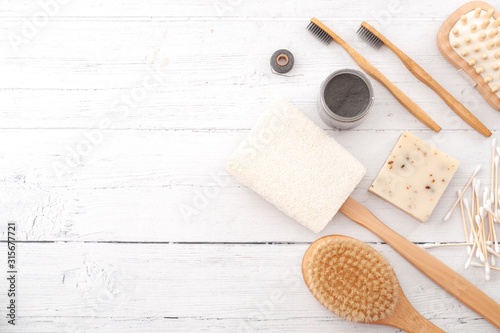 Sustainable and eco friendly beauty products, zero plastic lifestyle concept with homemade soap, natural loofah, bamboo toothbrush and foot massager isolated on white wood background with copy space