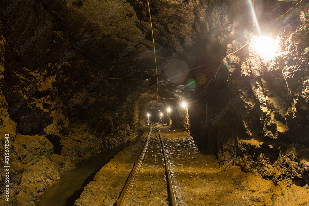 Naklejka premium Underground gold mine shaft tunnel drift with rails