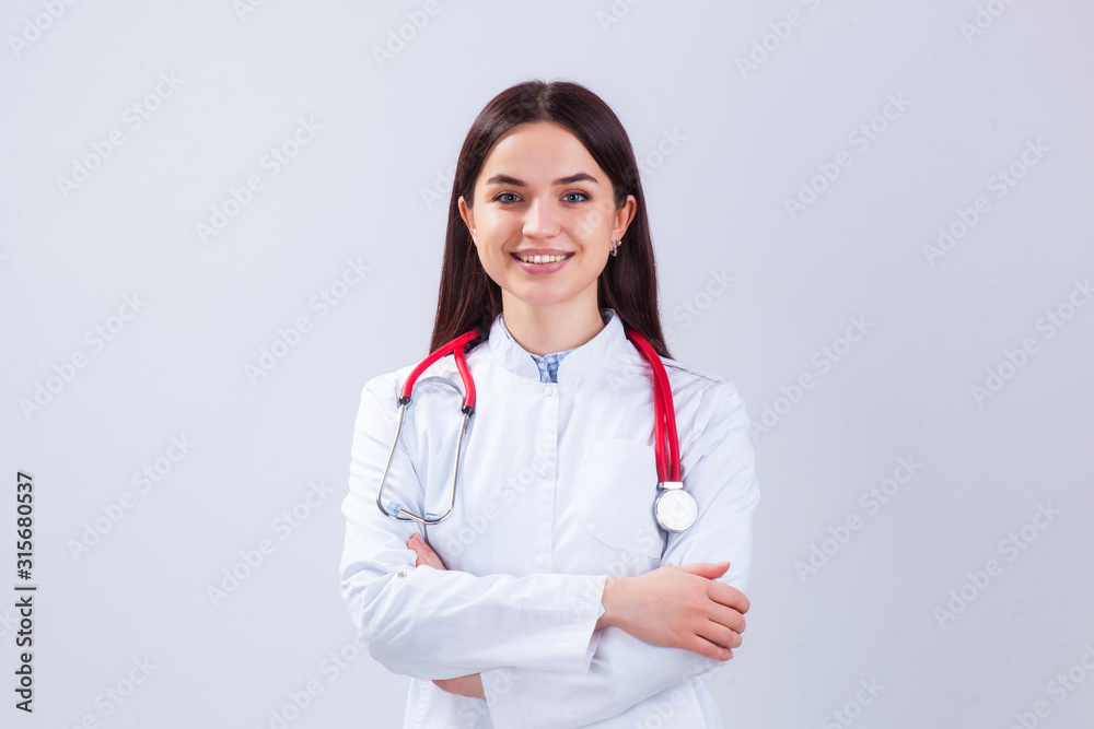 Medical concept of beautiful female doctor in white coat with phonendoscope. Medical student general practitioner. Woman hospital worker looking at camera and smiling, studio, gray background Medical concept of beautiful female doctor in white coat with phonendoscope. Medical student general practitioner. Woman hospital worker looking at camera and smiling, studio, gray background