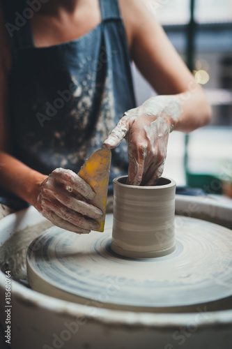 Tableau sur toile Vertical Image of Professional Female Maker Ceramics Working with Pottery Wheel