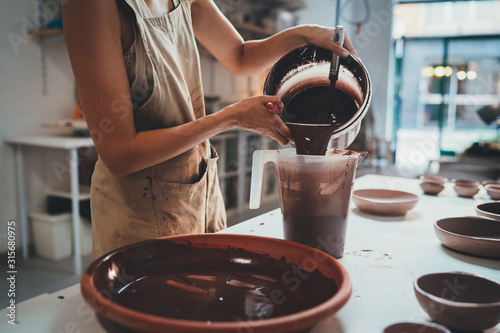 Closeup of Female Hands Glazing Handmade Big Bowl in Modern Pottery Workshop,  Handcraft Creative People Ceramic Art Design Pottery Making Process