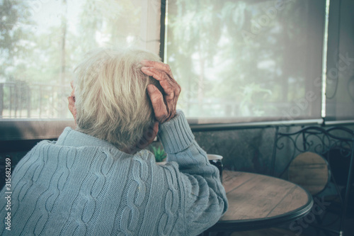 Adult woman / Old person has a headache. Concept dramatic loneliness, dementia, abuse, sadness, depression, sad emotions, cry, disappointed, healthcare, pain.