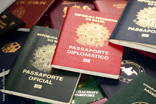 Different biometric passports of Brazil on the background of multi-colored documents of the world.