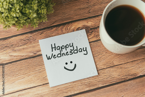 Happy Wednesday with smile greeting on paper note with cup of coffee photo