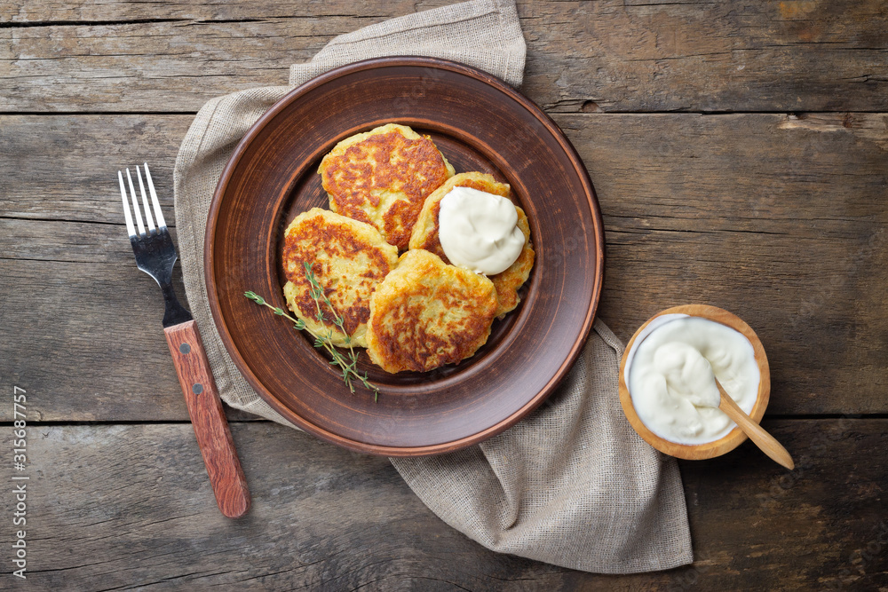Fried potato pancakes - draniki or deruny on a wooden table. Rustic style. Top view with copy space. Fried potato pancakes - draniki or deruny on a wooden table. Rustic style. Top view with copy space.