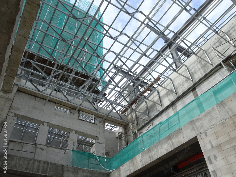 KUALA LUMPUR, MALAYSIA -JUNE 16, 2019: Lightweight roof trusses under construction at the construction site. Installed properly by workers to received the roof covering system. 