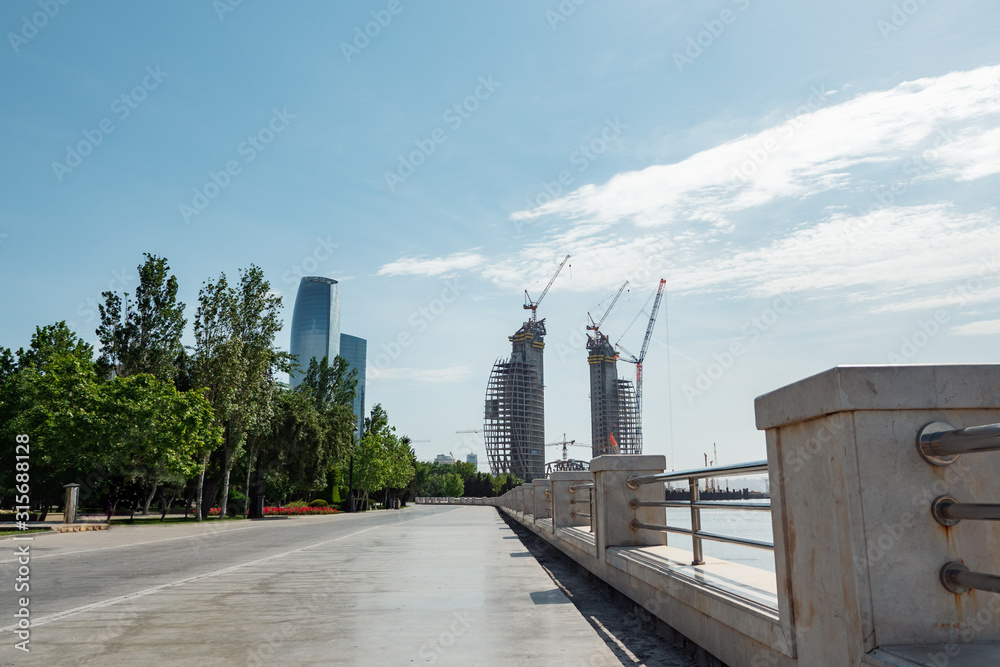Fototapeta premium Construction of high-rise buildings in Baku. View from the waterfront.