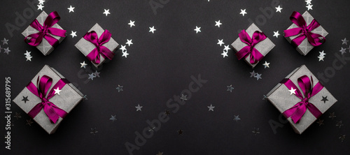 Red Christmas gifts, ornaments on black background. Winter holid © Maksym