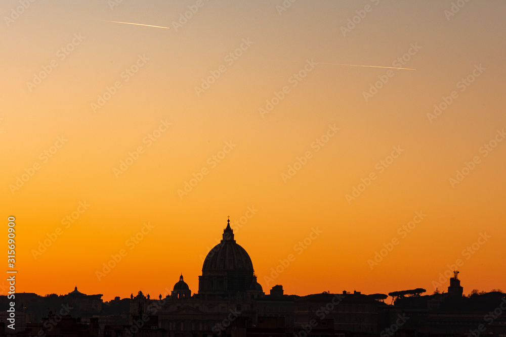 Rome, Italy: sunset and skyline with the Papal Basilica of St. Peter, the symbol of Catholicism, the largest church in the world, built in the Renaissance style in Vatican City, the papal enclave 