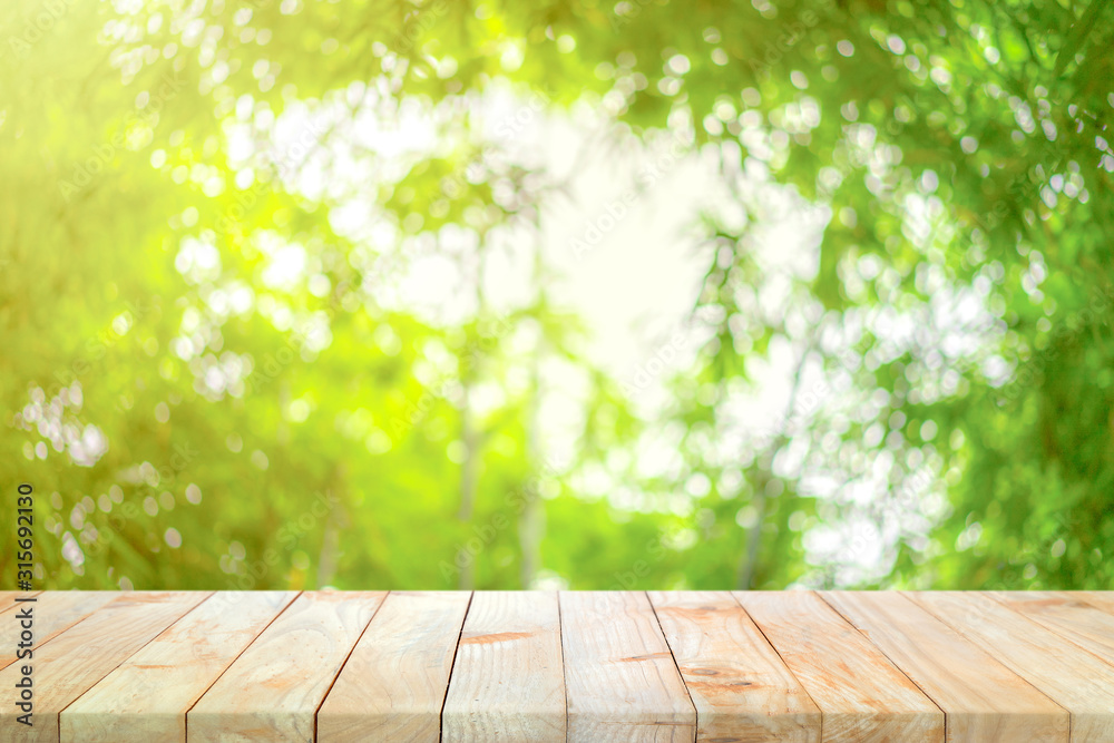 Wood board on the bamboo garden defocus blur background in the noon with orange - yellow sunlight from corner of image. This background can be used for packaging shot Wood board on the bamboo garden defocus blur background in the noon with orange - yellow sunlight from corner of image. This background can be used for packaging shot