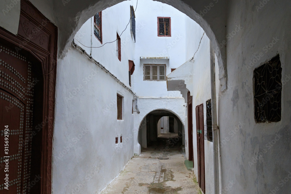 View of the old walls of Tetouan Medina quarter in Northern Morocco. A medina is typically walled, with many narrow and maze-like streets and often contain historical houses, palaces, places.