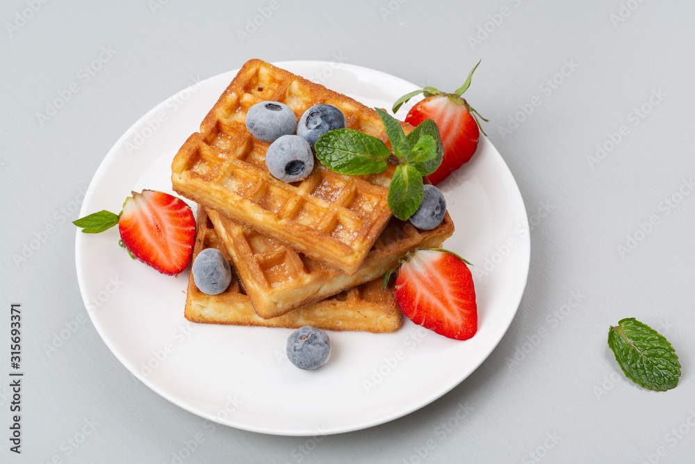 Belgian waffles with strawberries and blueberries for Breakfast. Belgian waffles with strawberries and blueberries for Breakfast.