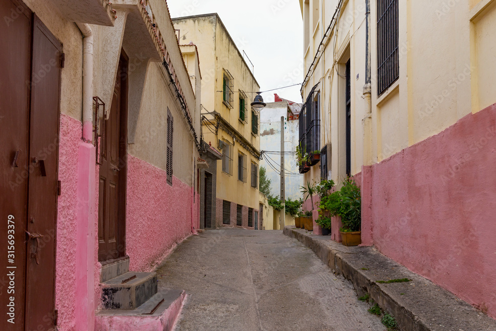 View of the one of the colorful old streets in the Tangier Medina quarter in Northern Morocco. A medina is typically walled, with many narrow and maze-like streets.