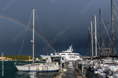 Wallpaper Mural Beautiful rainbow on stormy sky in marina with sailing and motor yachts and boats. Torontodigital.ca